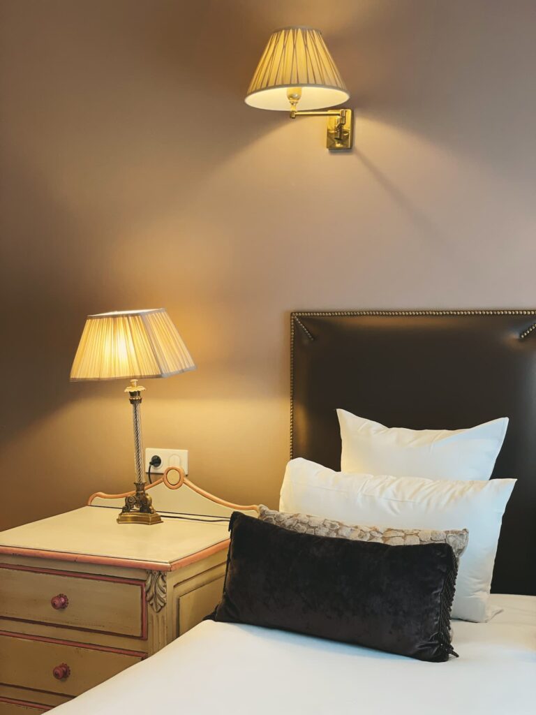 Brown and white bed with beige and pink furnitures in our family room - Hôtel des 2 Continents