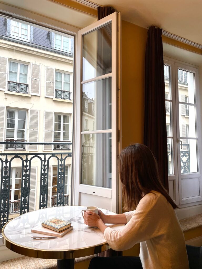 Drinking a coffee at the window on a rainy day in Paris - Hôtel des 2 Continents